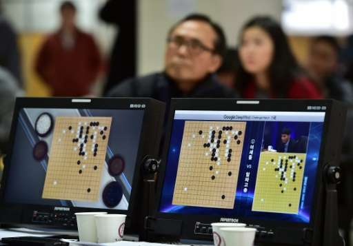 South Korean Go game fans watch a television screen broadcasting live footage of the Google DeepMind Challenge Match in Seoul on