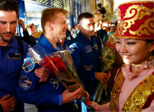 The International Space Station crew members Tim Peake, Yuri Malenchenko and Timothy Kopra receive flowers at Karaganda, Kazakhs