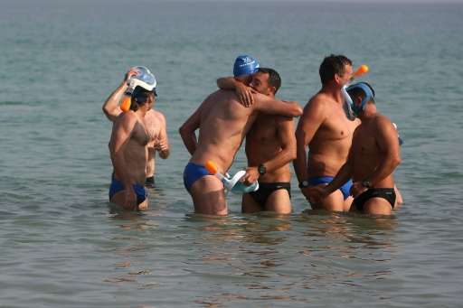 Participants greet each other as they arrive at the Israeli shore during a 17-kilometre swim from Jordan to Israel across the De