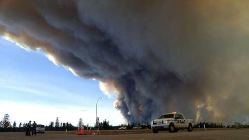 Members of the Royal Canadian Mounted Police monitor the fires around Fort McMurray in Alberta, Canada