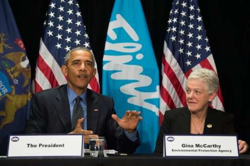 US President Barack Obama (L) speaks with EPA Administrator Gina McCarthy (R) during a meeting at the Food Bank of Eastern Michi
