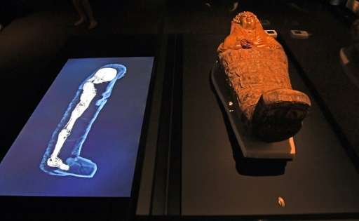 A 3D image of a CT scan of an Egyptian mummy is projected next to its sarcophagus