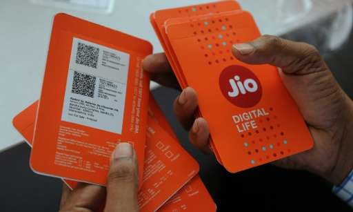 A customer in Mumbai selects a Reliance Jio Infocomm 4G mobile simcard offering an audacious free service for the rest of 2016