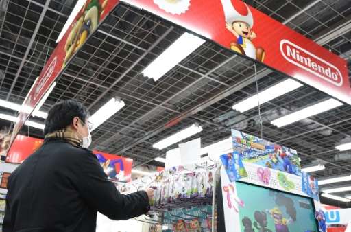 A customer looks at Nintendo video game software at a store in Tokyo