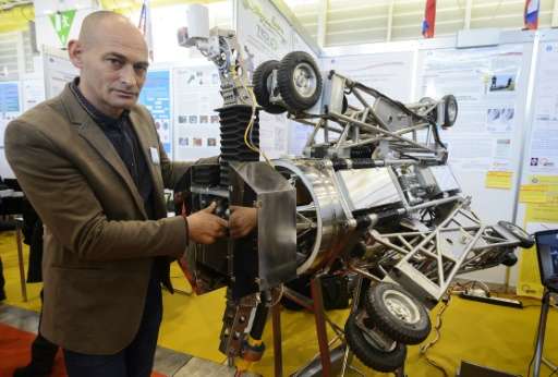 Adrian Tomoiaga of Romania, a member of a team of inventors, poses with an autonomous robot for the inspection and maintenance o