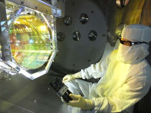 A Laser Interferometer Gravitational Wave Observatory optics technician inspects the equipment that will be used to conduct test