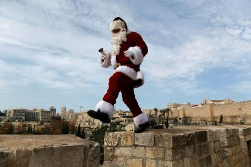 A man wearing a Santa Claus costume walks atop Jerusalem's Old City walls on December 23, 2016