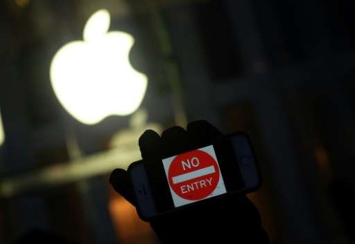 An anti-government protester holds up his iPhone with a &quot;No Entry&quot; sign during a demonstration near the Apple store on