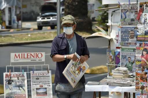 A newspaper vendor wears a surgical mask in smog-covered Mexico City on May 3, 2016