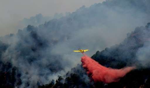 A plane fights a wildfire burning in Artana, near Castellon, eastern Spain on July 26, 2016