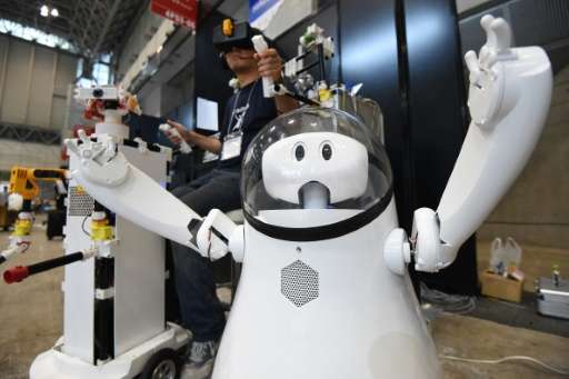 A prototype remote-controlled robot called &quot;Caiba&quot; is demonstrated by developer Katsumori Sakakibara (L) during a pres