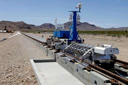 A recovery vehicle and a test sled sit on rails after the first test of the propulsion system at the Hyperloop One Test and Safe