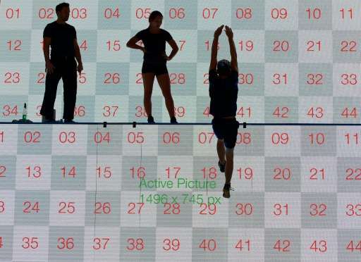 Artists perform in front of a screen at the Busch-Jaeger booth at the IFA electronics trade fair in Berlin