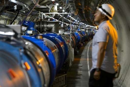 A scientist looks at a section of the Large Hadron Collider (LHC), at the European Organization for Nuclear Research (CERN) in M