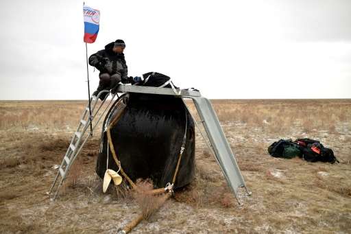 A search and rescue team secures the Soyuz TMA-18M space capsule carrying International Space Station crew US astronaut Scott Ke