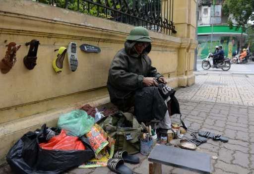 A street cobbler repairs shoes in Hanoi, which experienced its coldest weather for two decades over the weekend according to sta