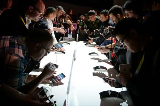 Attendees check out LG G Flex2 smart phones, during the 2015 Consumer Electronics Show in Las Vegas, Nevada