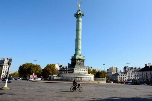 A woman rides a bicycle at Place de la Bastille on September 27, 2015 in Paris, France