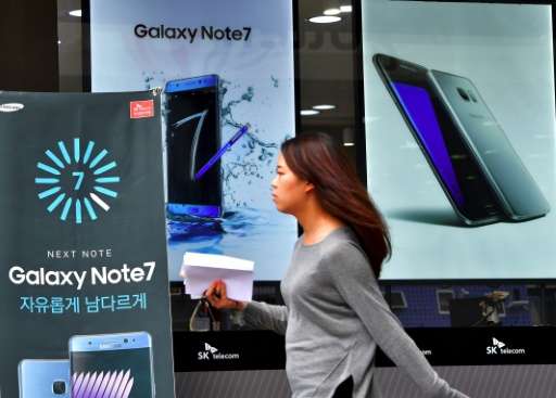A woman walks past billboards of Samsung Galaxy Note 7 and Galaxy S7 at a mobile phone shop in Seoul on September 12, 2016