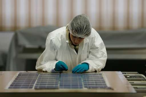 A woman works on a solar panel at the SNA factory in Tourouvre