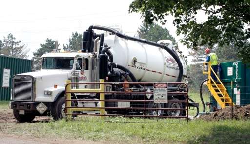 A worker unloads oil that has been removed from the Kalamazoo River after a 30 inch-wide underground pipeline owned by Calgary, 
