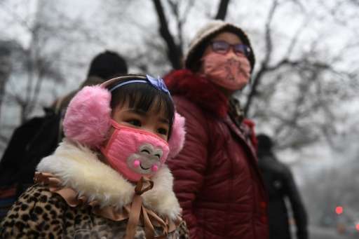 A young girl waits to cross a road in Shijiazhuang on December 21, 2016