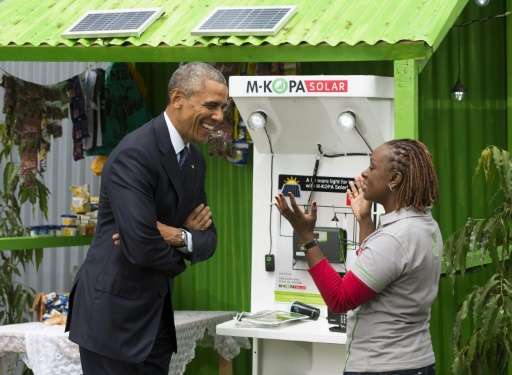 Barack Obama (left) talks with June Muli about solar power in Nairobi last year