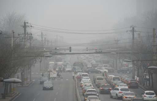 Cars driving below a blanket of smog on a heavily polluted day in Beijing