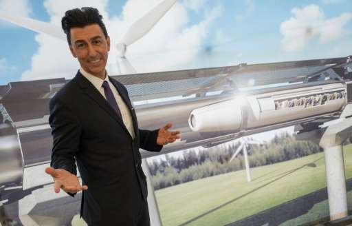Chairman of Hyperloop Transportation Technologies Inc Bibop Gresta poses in front of a rendering of the Hyperloop technology, at