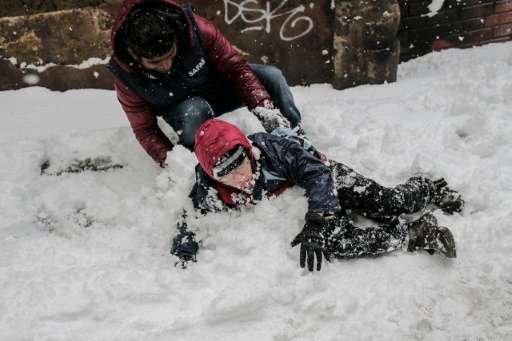 Children play in the snow in Istanbul on December 31, 2015