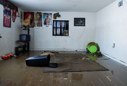 Debris and water covers a floor in the home of Debbie and Benton Kelly in Pacific, Missouri on January 1, 2016