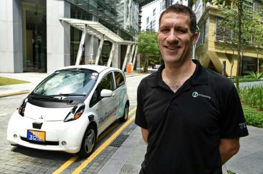 Doug Parker, COO of nuTonomy, the developer of the software for driverless taxis, pictured alongside one of the vehicles during 