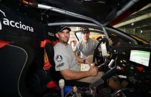 Driver Ariel Jatton (L) and co-driver Gaston Daniel Scazzuso of Argentina pose inside their Acciona Eco Power ahead of the 2016 