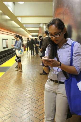 Edith Duro plays Pokemon Go as she awaits a train in downtown San Francisco on July 12, 2016