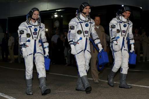 First-time astronauts Kathleen Rubins of NASA (L) and Takuya Onishi of the Japanese space agency (R) set off for a four-month mi