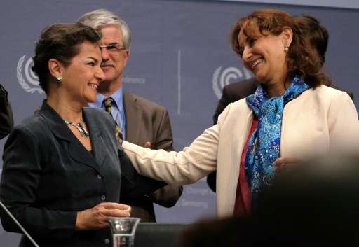 French Environment minister Segolene Royal (right) hands over a gift to Christiana Figueres—Executive Secretary of the United Na