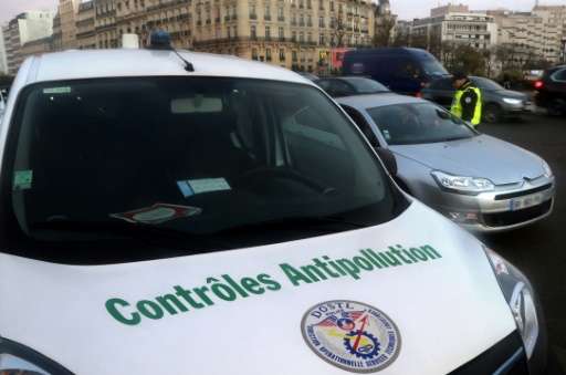 French traffic police control cars as they try to enforce the anti-pollution measures across Paris, on December 8, 2016