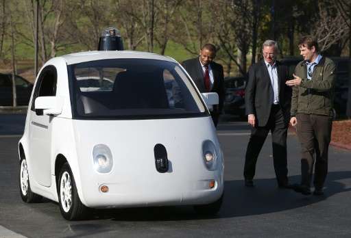 Google's Chris Urmson (R) shows a Google self-driving car to U.S. Transportation Secretary Anthony Foxx (L) and Google Chairman 