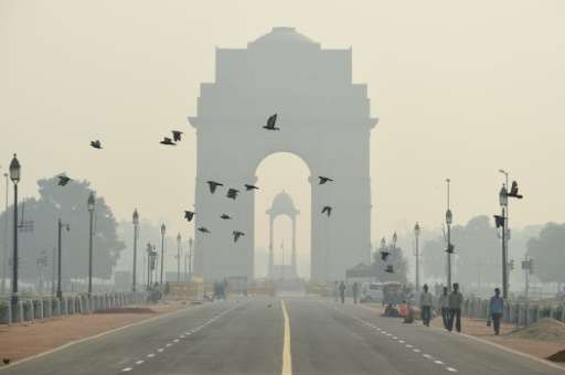 Indian pedestrians walk near the India Gate monument amid heavy smog in New Delhi on October 28, 2016