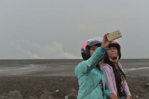 Indonesian tourists take selfies in Sidoarjo, East Java, where a mud volcano erupted in May 2006 swallowing entire villages