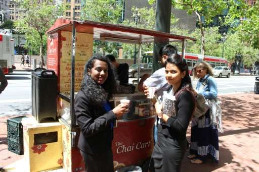 Jyothi Lakshmaiah (L) and Nithya Krishnan (R) take a break from their jobs  to enjoy chai from a Chai Cart on Market Street in d