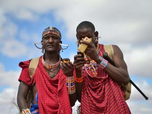 Kenyan Maasai 'Morans' (warriors) relay the GPS coordinates of the location of two-young lionesses they have been tracking on fo