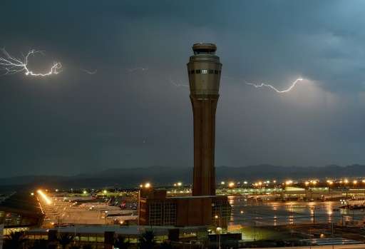 Lightning flashes behind an airport control tower on July 6, 2015 in Las Vegas, Nevada