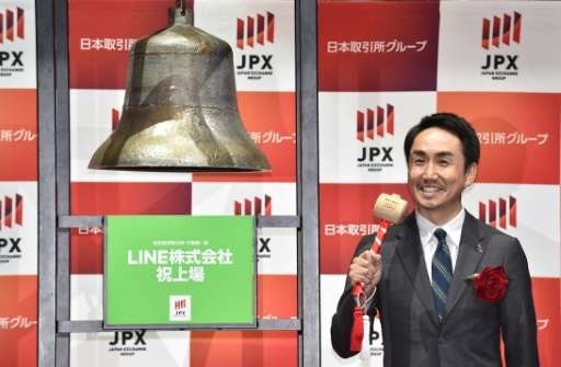 Line Corp. president and chief executive officer Takeshi Idezawa rings the bell during ceremony for the company's listing at the
