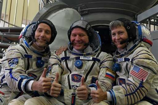 (L-R): France's astronaut Thomas Pesquet, Russia's cosmonaut Oleg Novitsky and US astronaut Peggy Whitson in front of a Soyuz sp
