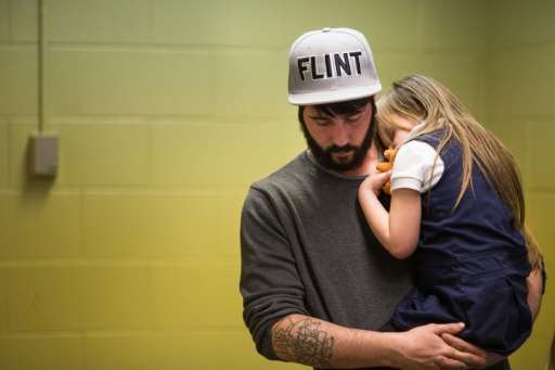 Matt Hopper comforts Nyla Hopper, age 5 of Flint, after she has her blood drawn to be tested for lead at Eisenhower Elementary S