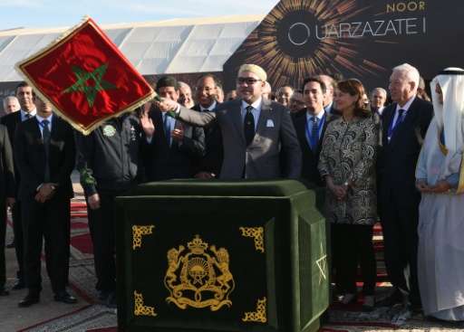 Moroccan King Mohammed VI (C) waves the Moroccan flag as he inaugurates the Noor 1 Concentrated Solar Power plant, some 20 kilom