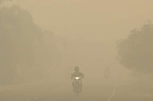 Motorists drive through a thick haze in Palembang, on Indonesia's Sumatra island in September 2015