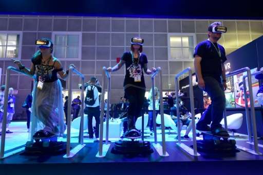 People 'skateboard' while sampling Samsung's Gear VR headsets powered by Oculus at the Los Angeles Convention Center during the 