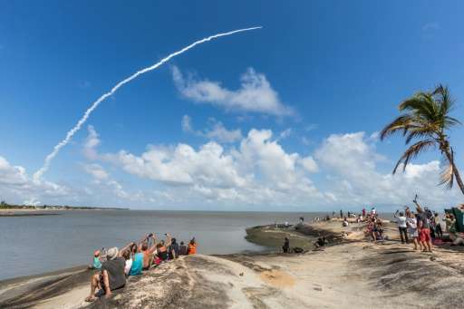 People take photos as an Ariane 5 space rocket with a payload of four Galileo satellites lifts off from ESA's European Spaceport